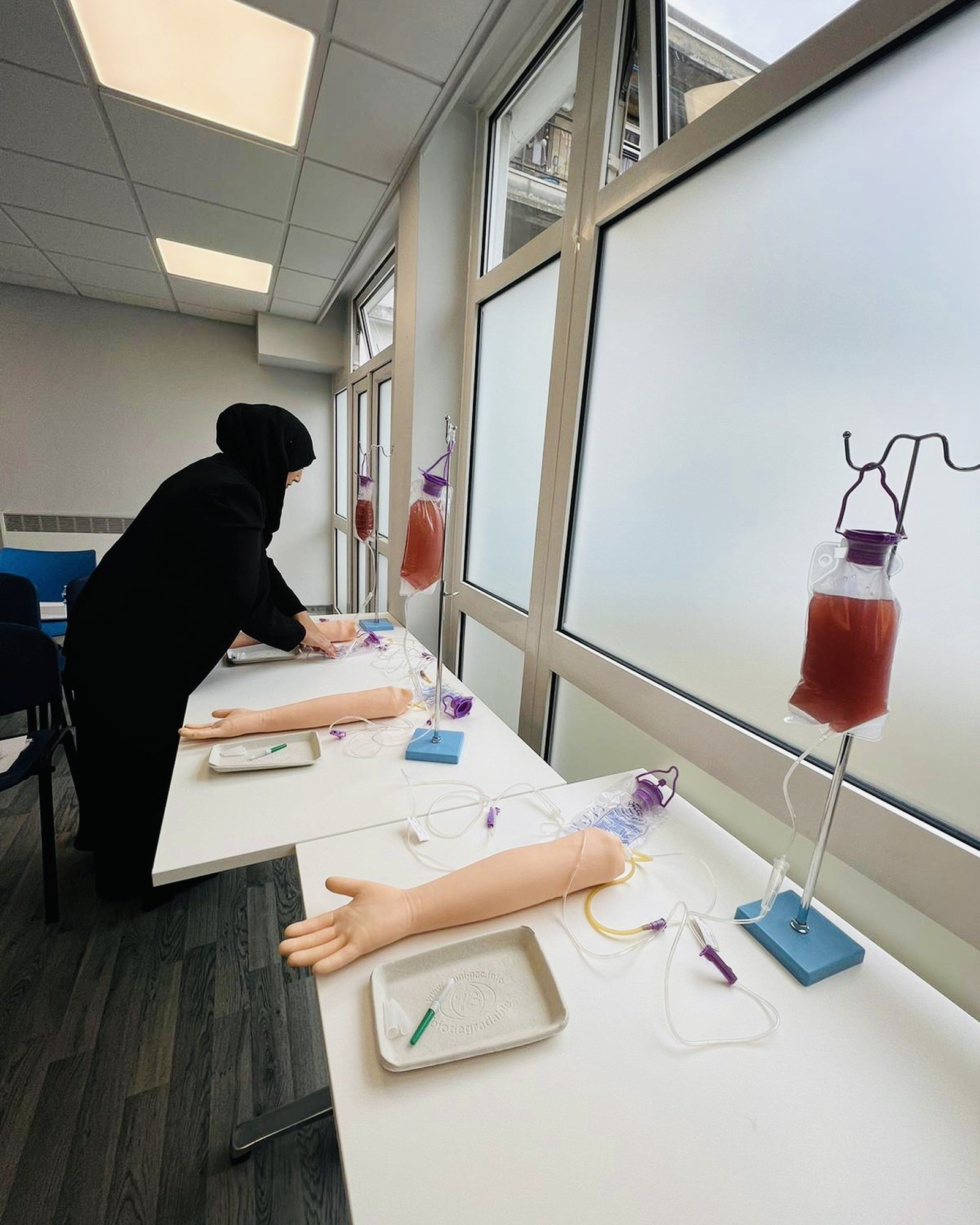 Phlebotomy trainer performing a live blood draw in an NHS GP surgery
